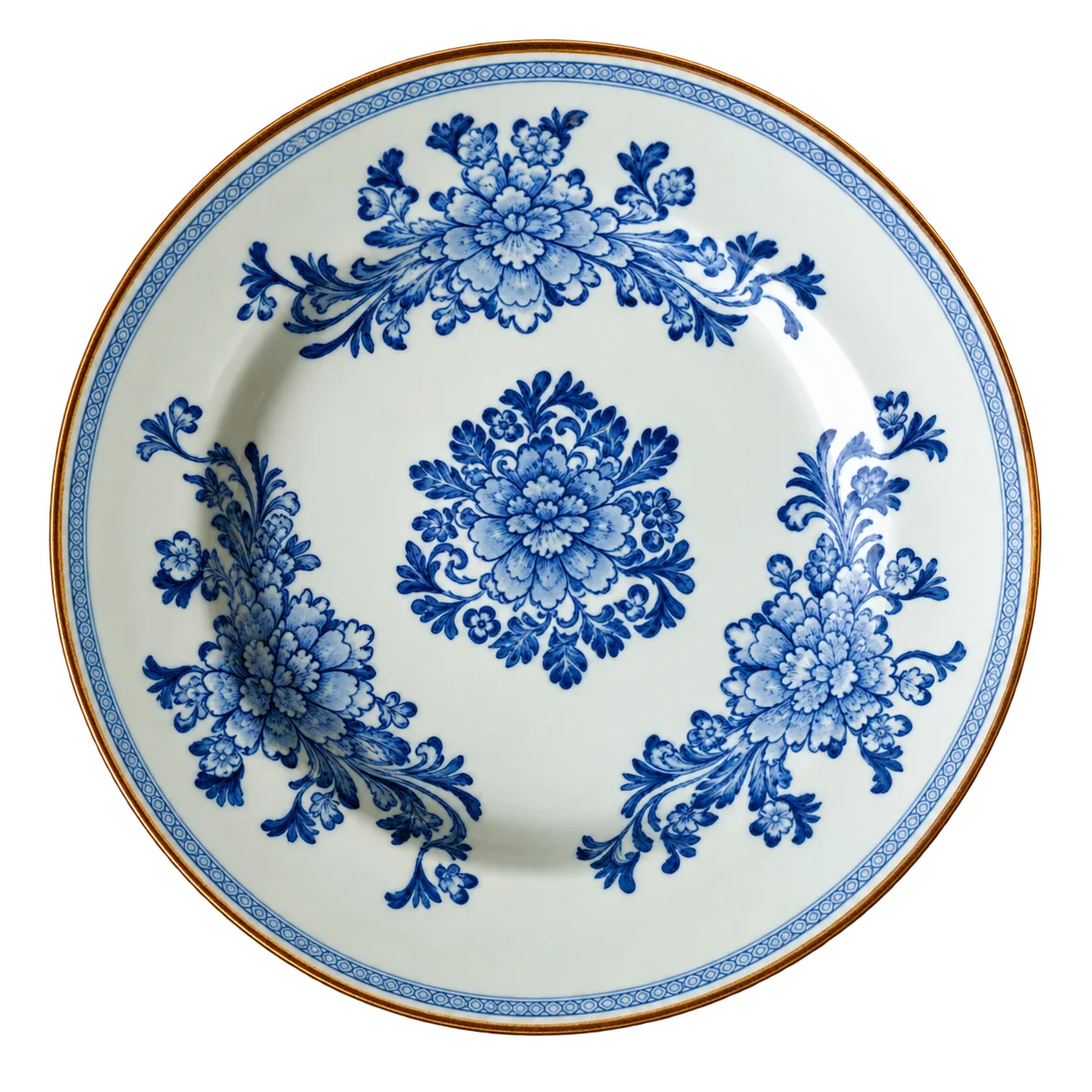 Une assiette ancienne en céramique blanche ornée de motifs floraux bleus, photographiée seule sur un fond blanc uni.