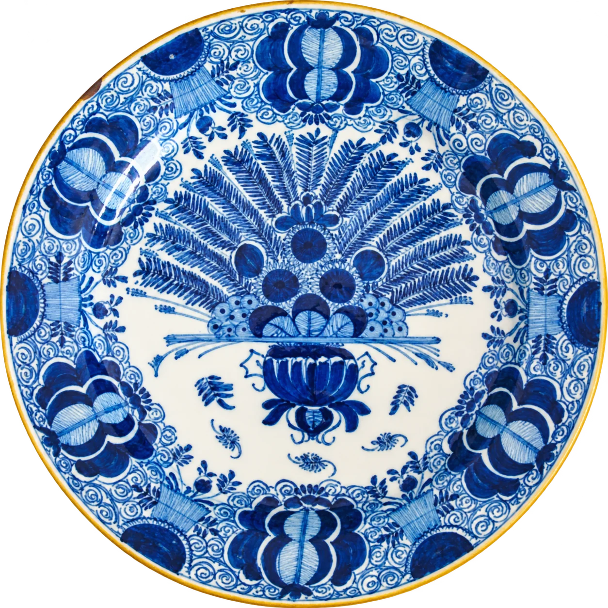 Assiette ancienne en faïence à décor bleu cobalt sur fond blanc, avec un grand bouquet en éventail au centre et des motifs floraux sur le bord.