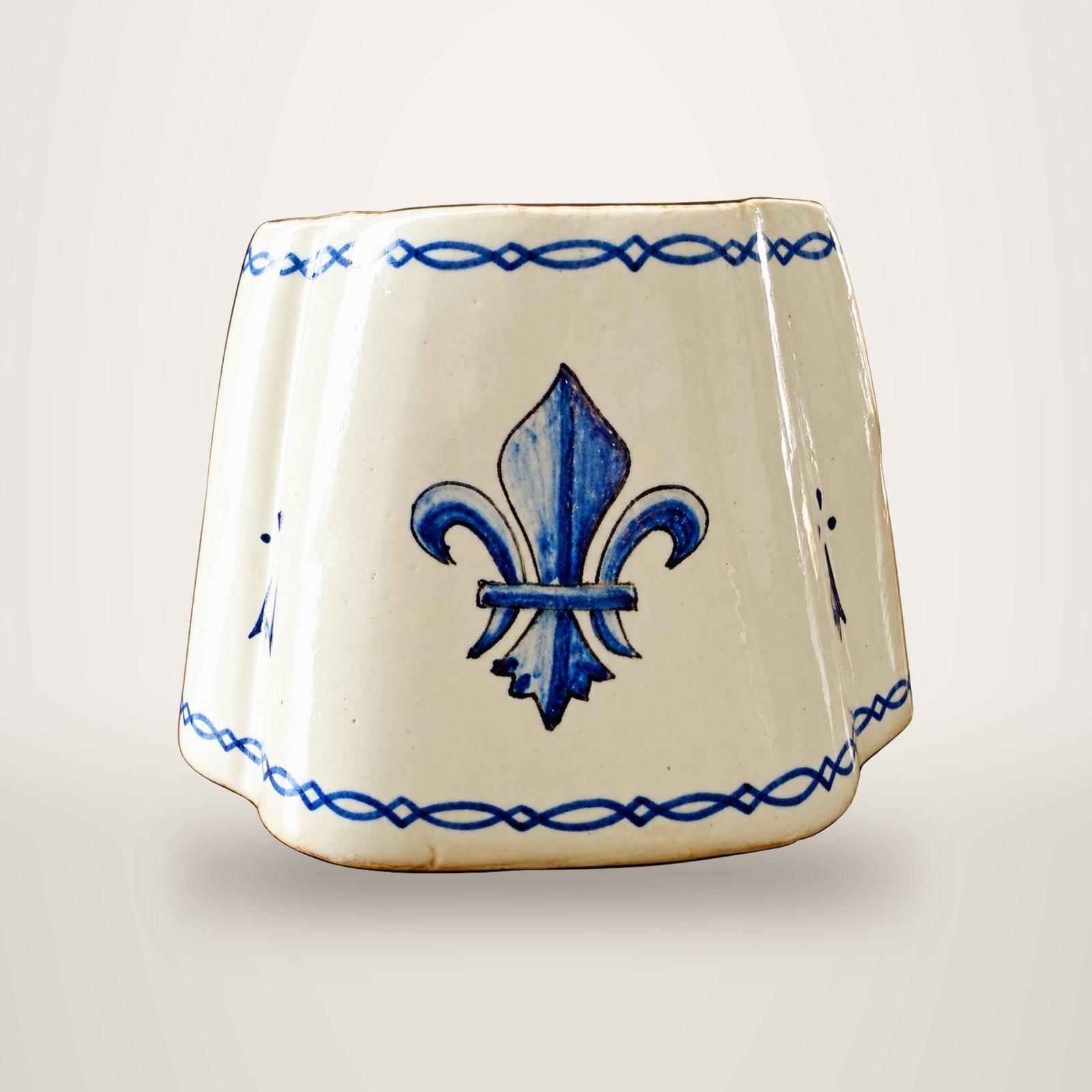 Pot en céramique crème aux angles arrondis, orné d'une fleur de lys bleue peinte à la main et de frises bleues.