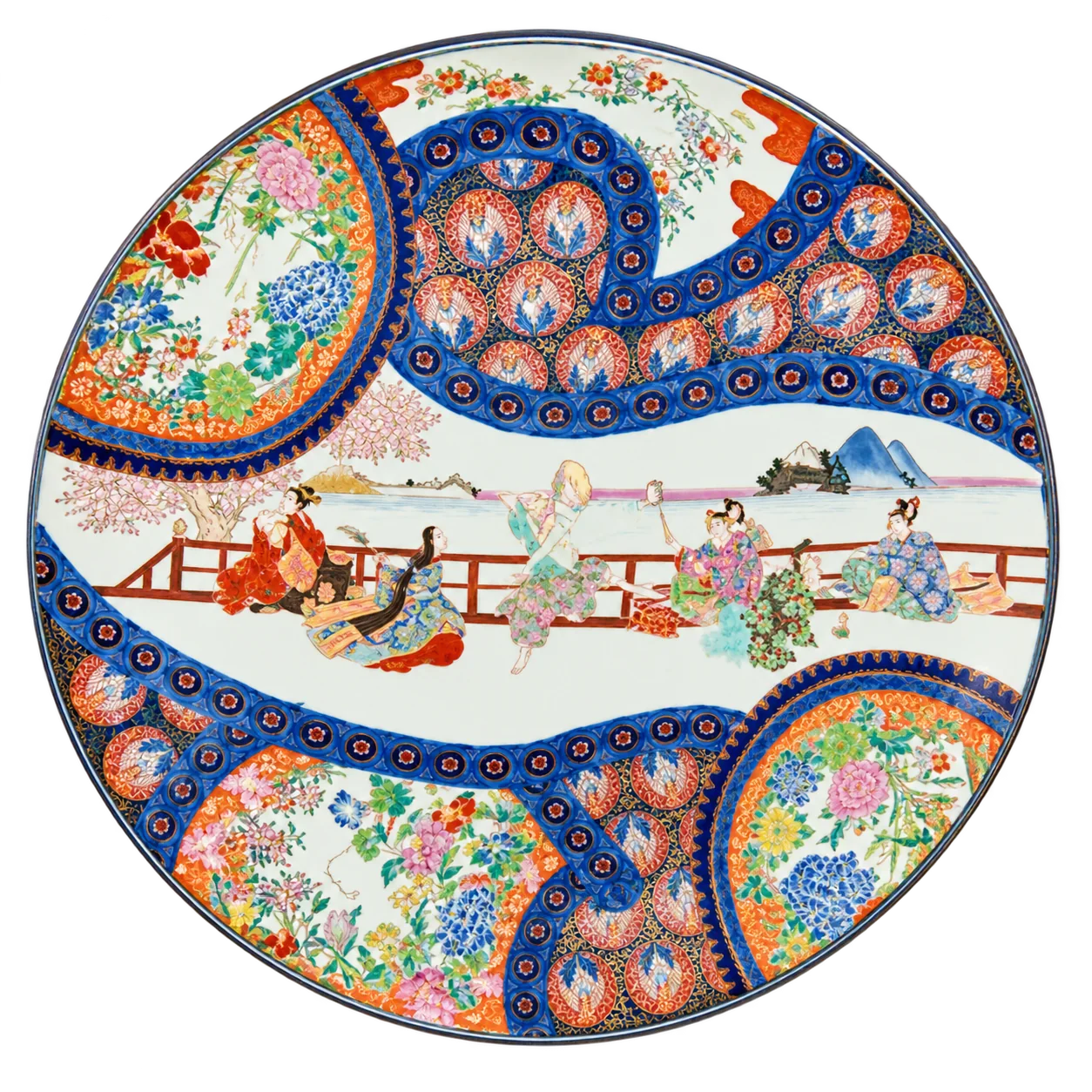Grand plat en porcelaine aux motifs japonais colorés, avec des personnages près d'une balustrade et des médaillons de fleurs bleus, rouges et verts, présenté sur fond blanc.