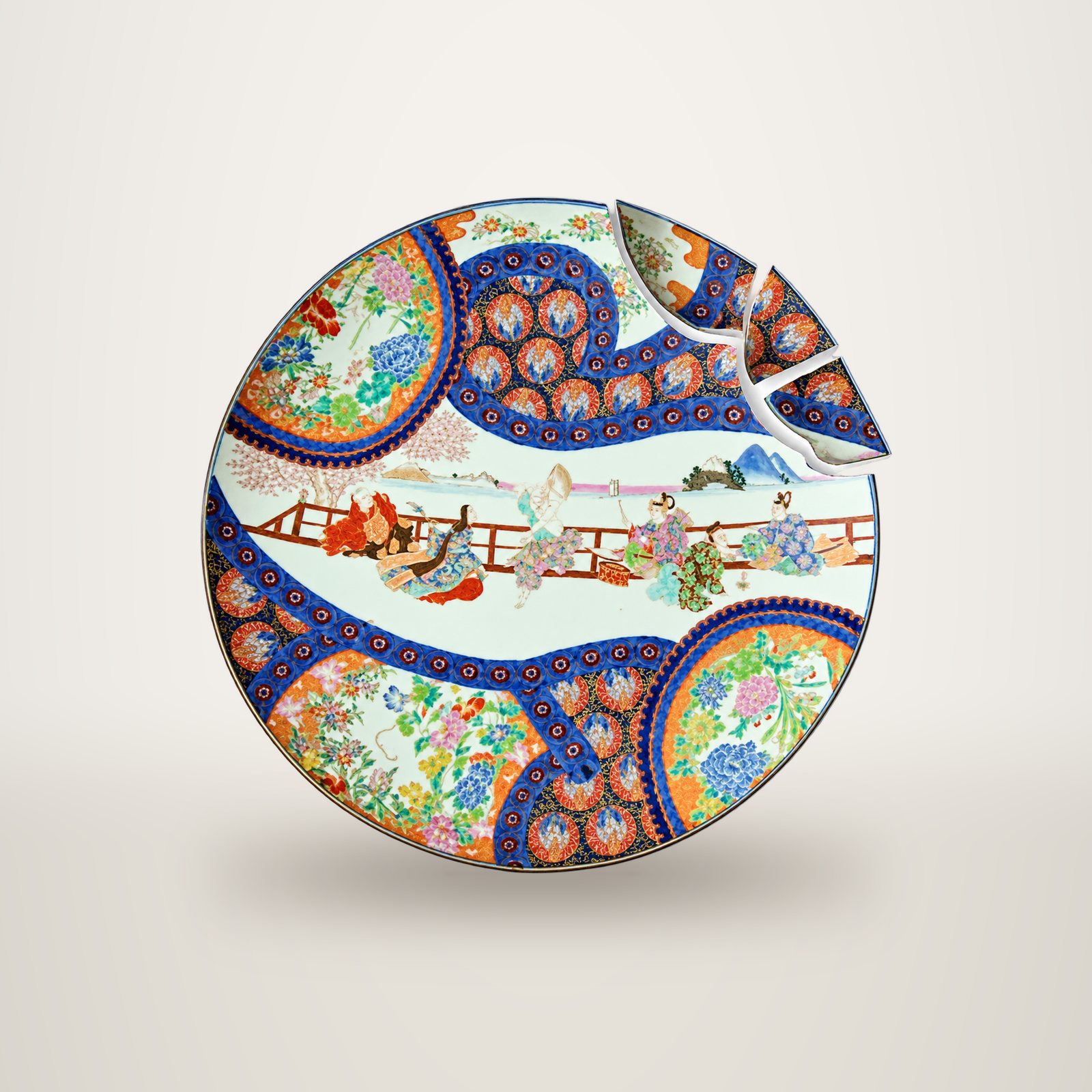 Grand plat rond en porcelaine japonaise polychrome orné de personnages et de motifs floraux, dont trois fragments détachés sont placés au bord supérieur droit.