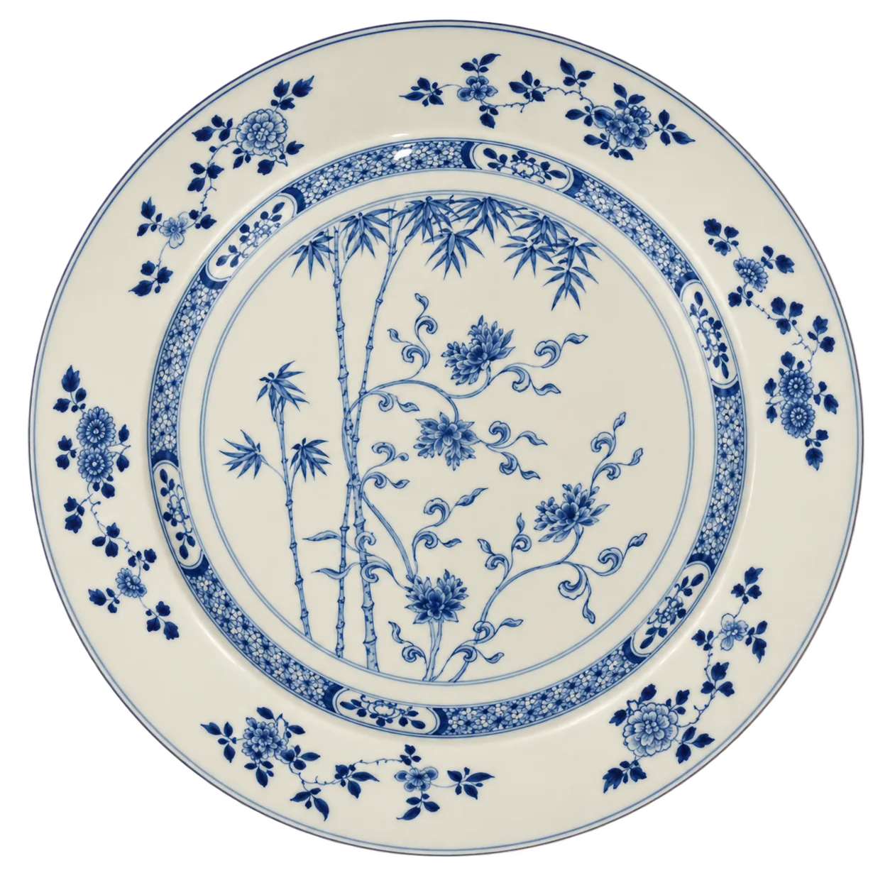 Grand plat rond en porcelaine blanche décoré en bleu de bambous et de fleurs, avec une bordure ornée de motifs floraux.