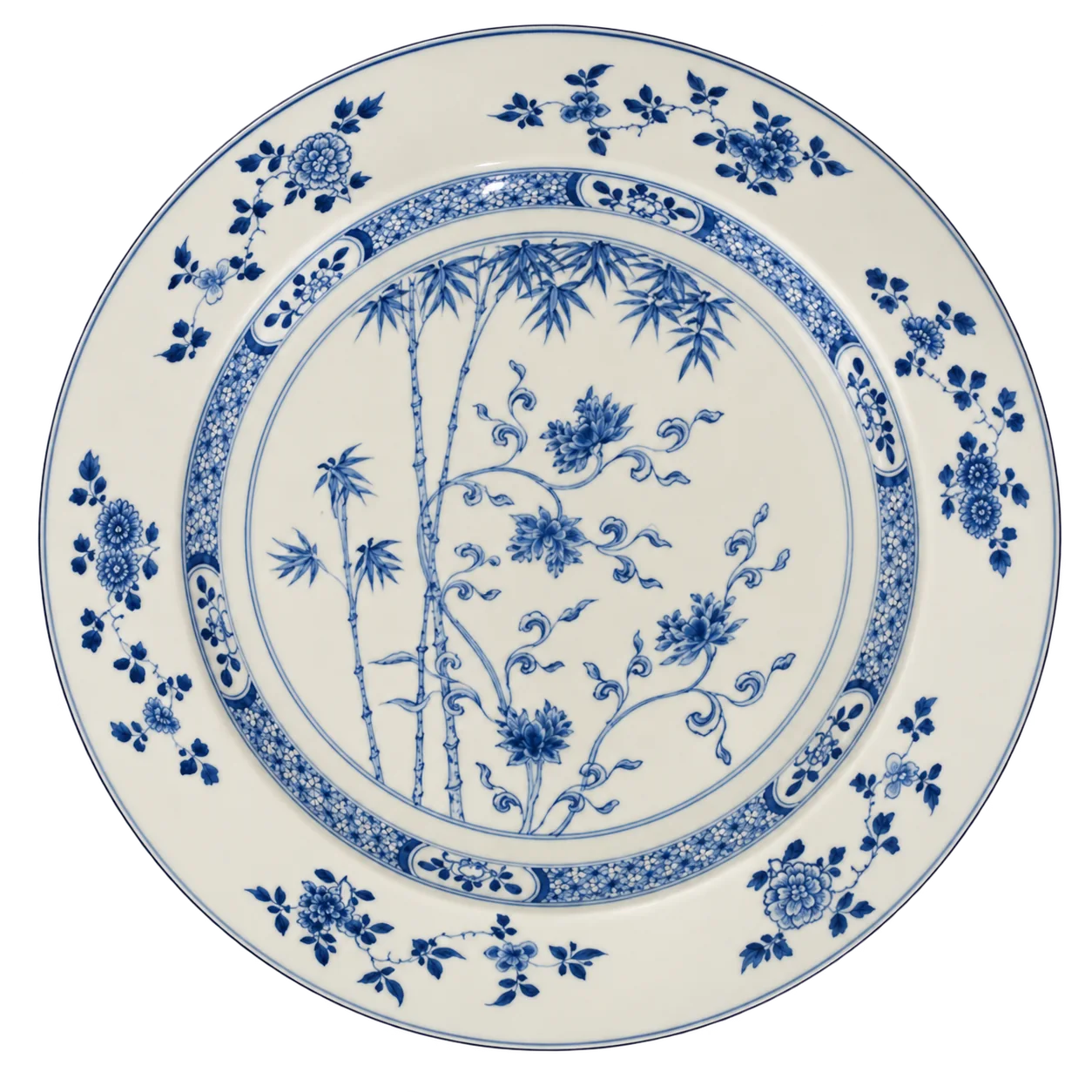 Grand plat rond en porcelaine blanche décoré en bleu de bambous et de fleurs, avec un bord orné de motifs floraux.