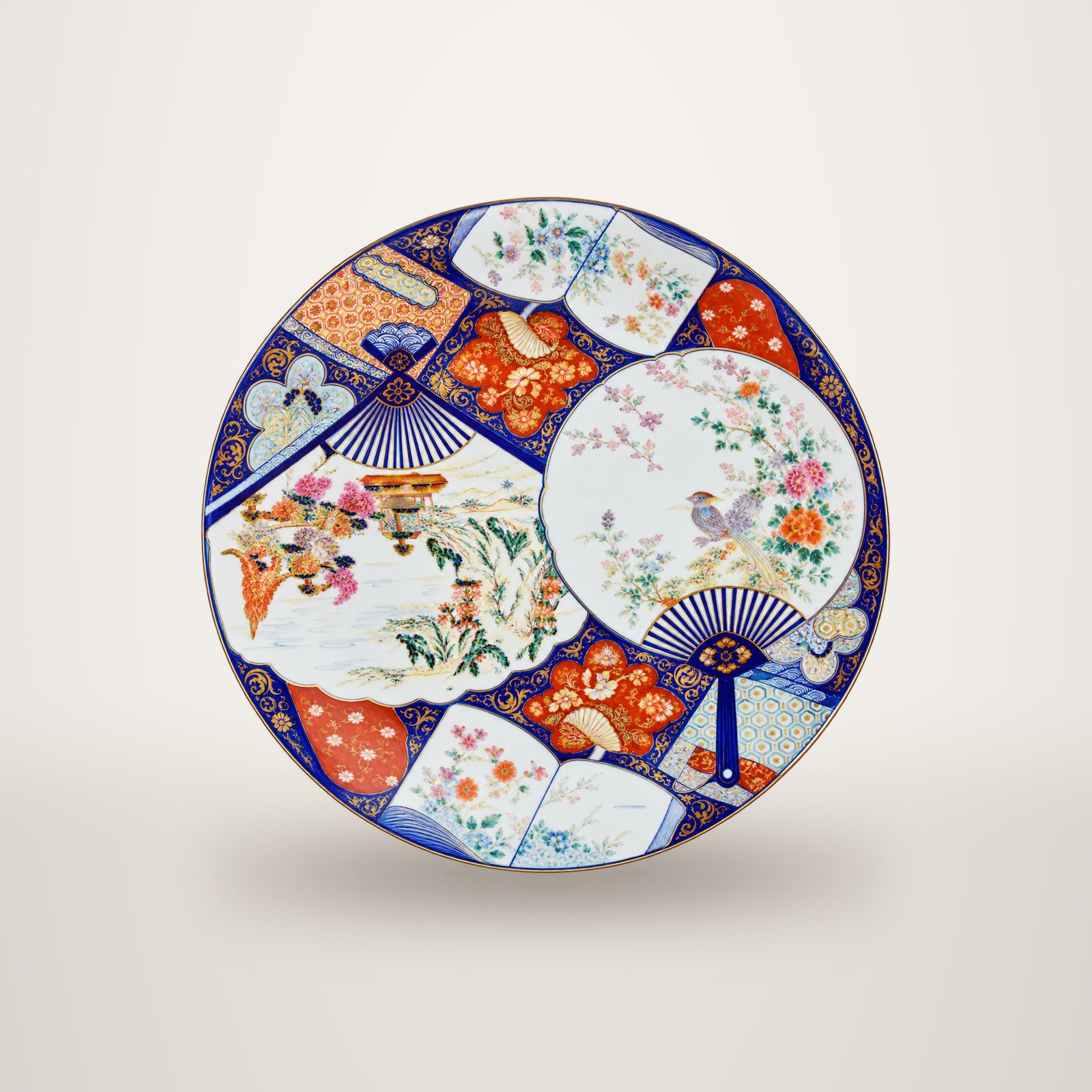 Un grand plat rond en porcelaine de style Imari, décoré d'éventails aux motifs de fleurs et d'oiseaux en bleu, rouge et or.
