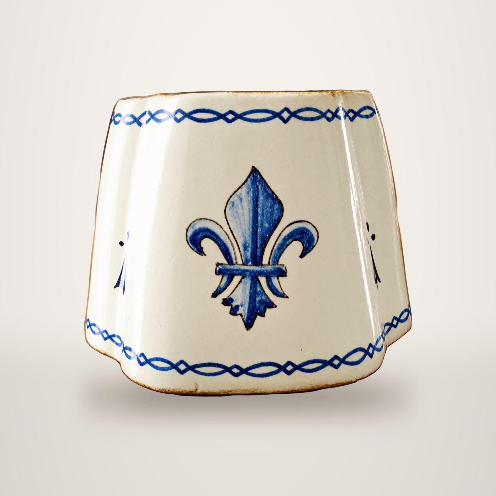 Pot en céramique émaillée blanche à pans coupés, orné d'une fleur de lys bleue peinte à la main et de frises bleues.