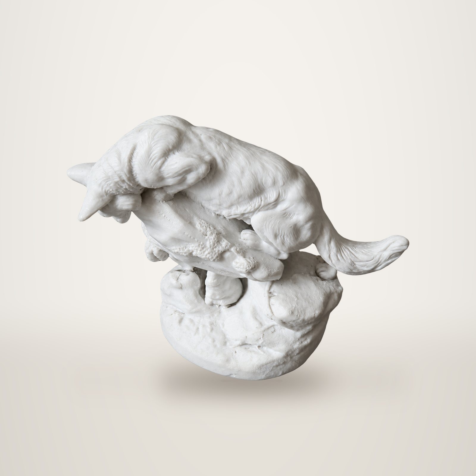 Statuette blanche en biscuit de porcelaine représentant un renard penché sur un tronc, posé sur un socle en forme de rocher.